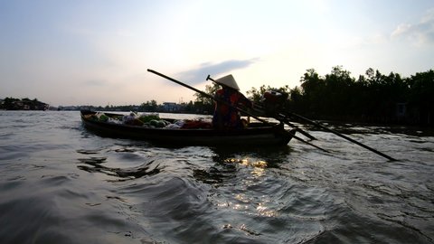 Female Vietnamese market vendor travelling by boat selling fresh organic produce to local villages along the Mekong river travel and tourism
