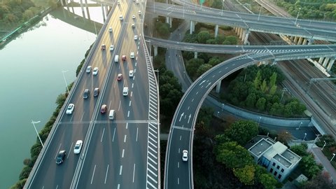 Aerial view of road junction with moving cars. Road interchange or highway intersection with busy urban traffic speeding on the road.