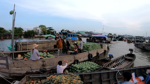 Vietnam - June 2019: People on the Mekong at sunrise wholesale fruit and vegetable selling and buying on floating market Asia travel and tourism