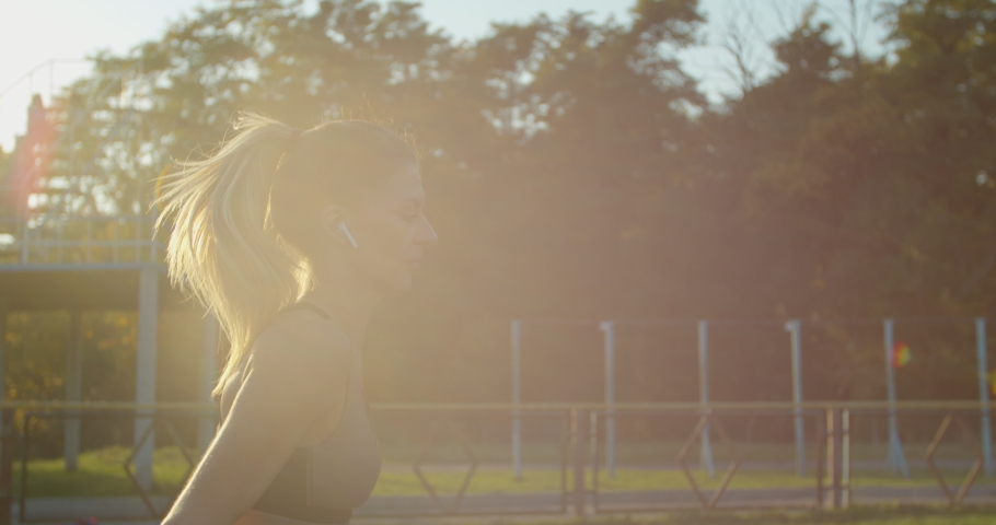 Portrait of Woman running at a stadium in sunny day.
