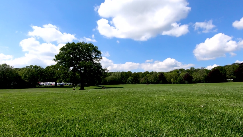 Panning around at a low perspective of the open grass area of the war memorial park in Coventry on a warm spring day