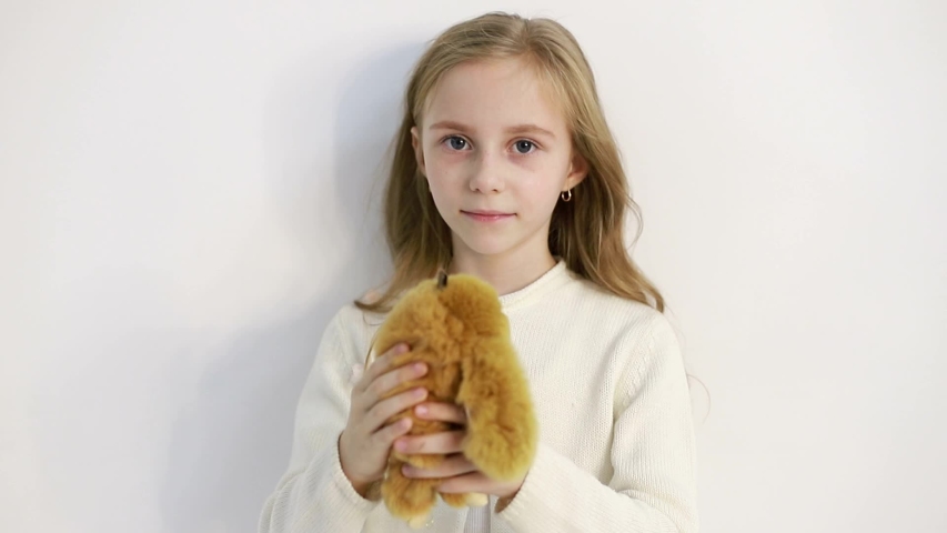little girl with favorite toy, baby on a white background