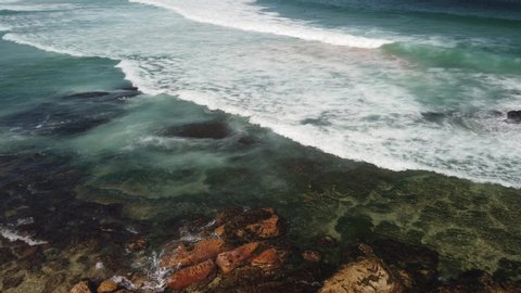 Rocky shore break, wave splash rock create sea mist, australian coastal line. Bondi beach coast nature walk, clear water wave front with deep blue sea sky on bright sunny day high angle shot on cliff