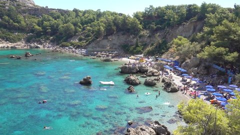 Anthony Quinn Bay Mediterranean coast, rocky coast, beach, beach umbrellas, people relax, Rhodes island Greece.