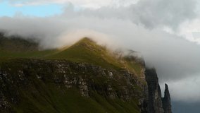 Gorgeous timelapse video on famous Witches Finger cliffs and dramatic cloudy sky from Trollkonufingur viewpoint. Vagar island, Faroe Islands, Denmark. UHD 4k video
