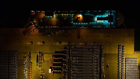 Time lapse. Aerial at night view from drone, Ro-Ro Ship, Business logistic and transportation of cars in port , Trade Port , Cargo car Transport, cargo to harbor