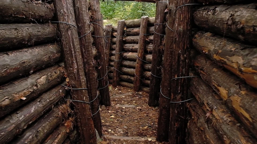 POV moving along wooden trench or foxhole used by military in Second World War. Steadicam shot