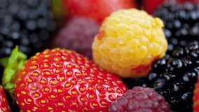 Closeup 4k dolly footage of strawberry, raspberry, blueberry and blackberry on table. Perfect abstract backdrop for culinary or healthy food.