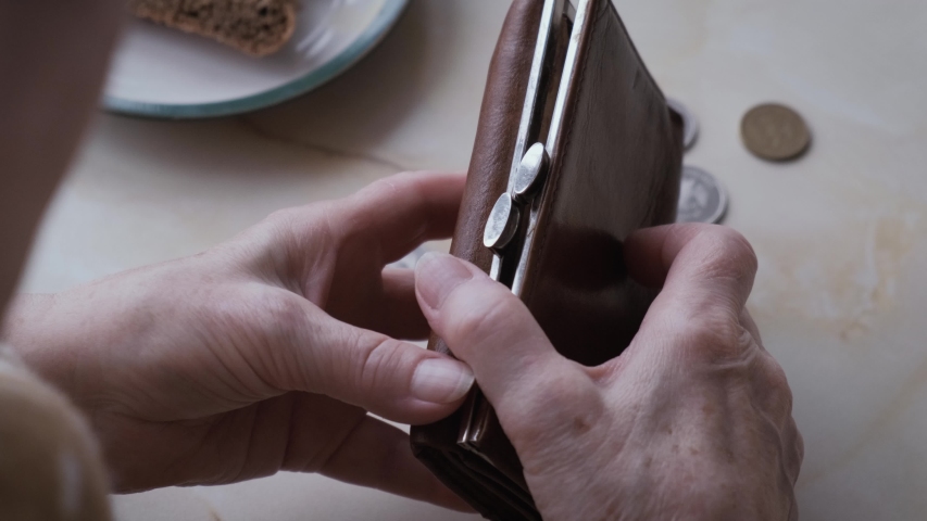 Hands of an elderly poor woman open an empty wallet, close-up