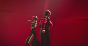 4K Beautiful couple dancing latin dance . Professional dancers dancing flamenco, rumba or salsa on red background. Pair in spanish dress performs dance movement. Shot ARRI ALEXA Cinema Camera .