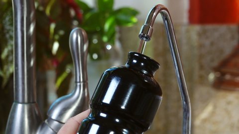 A step closer to a plastic free lifestyle: refilling a metal water bottle at the sink.