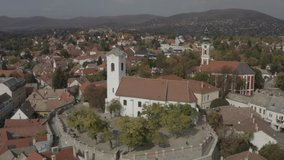 Catholic small town in autumn with church, Szentendre, Hungary, Europe aerial stock video. RAW footage for creators to color grade and control the look of your project (dlog, d log).