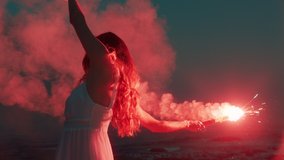 woman waving red flare dancing on beach at dawn expression creative freedom burning distress signal firework - Powered by Shutterstock - Get 15% off with code: PIKWIZARD15