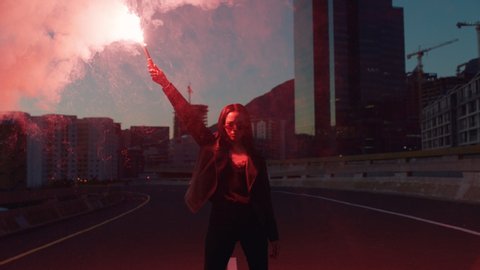 independent woman holding red flare in city at sunrise rebellious girl protesting for equality in street with firework female millennial freedom movement