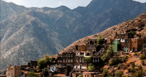 Rijal Almaa, Asir region, Saudi Arabia - 23 - 09 - 2017 : Rijal Almaa world heritage site day time outdoor timelapse stone buildings and green mountains with cloudy sky
