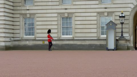 London, UK - April, 2019: British guard in traditional red-black uniform on military duty in the army of the Queen of England. British Guard on duty at London Buckingham Palace