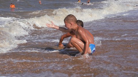 Beach summer vacation. Children in the raging waves.