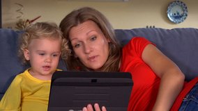 mother with daughter blow kiss to father on tablet video conversation.