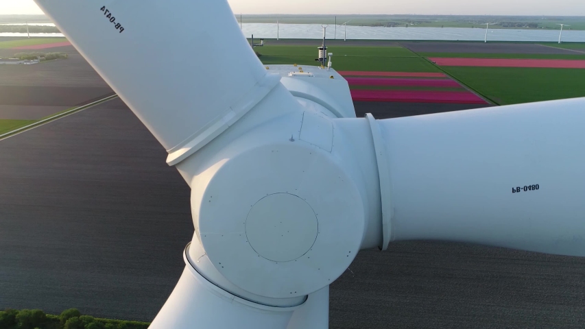 Aerial close up sundown footage of wind turbine front or alternatively referred to as a power converter is device that converts winds kinetic energy into electricity in environmentally friendly way Royalty-Free Stock Footage #1041180922