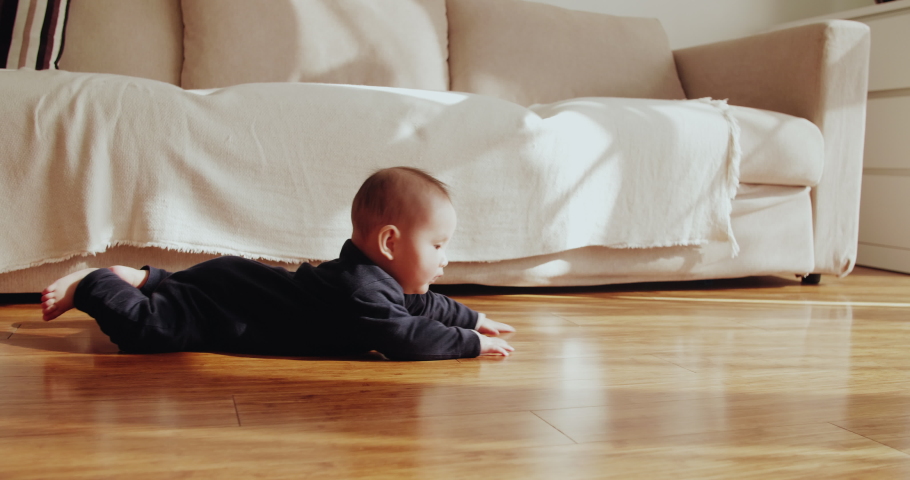 One baby girl crawling on the floor at home side view of baby asian girl learning to crawl Royalty-Free Stock Footage #1041188821