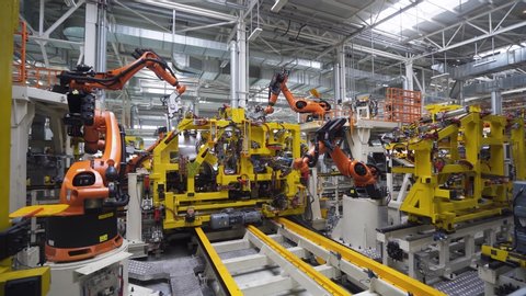 BELARUS, BORISOV - AUGUST 7, 2019: Automobile plant, modern production of cars, car body welding process, robots at work, build process in automated production line.