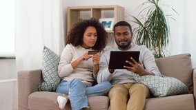 family, technology, online shopping and people concept - happy african american couple couple with tablet pc computer and credit card at home - Powered by Shutterstock - Get 15% off with code: PIKWIZARD15
