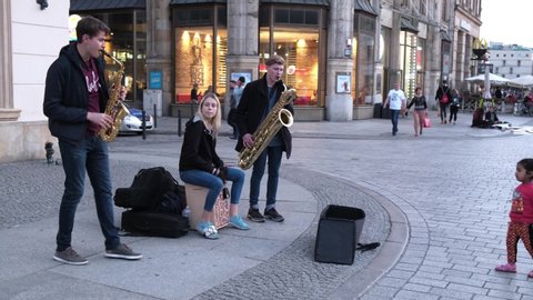 WROCLAW, POLAND - NOVEMBER, 2019.  Group of young street musicians play the saxophones and drums modern music on a tourist center of old city. Footage with sound.