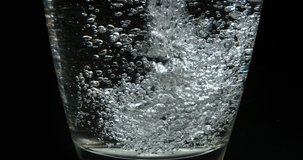  Water being poured into Glass against Black Background, Slow Motion 4K
