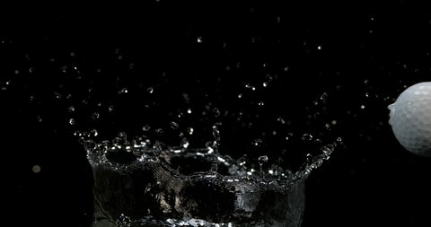 Golf's Ball Falling into Water against Black background, slow motion 4K