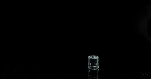Glass of Water Bouncing and Splashing on Black Background, Slow Motion 4K