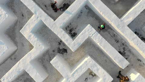 HARBIN, CHINA – JANUARY 2019: Rising rotating drone shot of people getting lost in spectacular snow maze during famous Harbin ice festival, Winter activities and entertainment in China