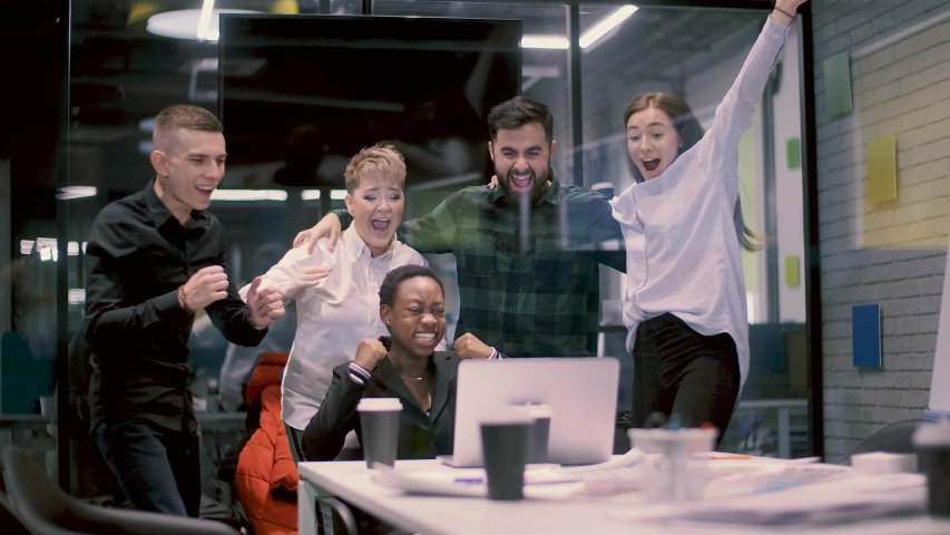 Group of businessmen of different races hugging and dancing because of succesful project.