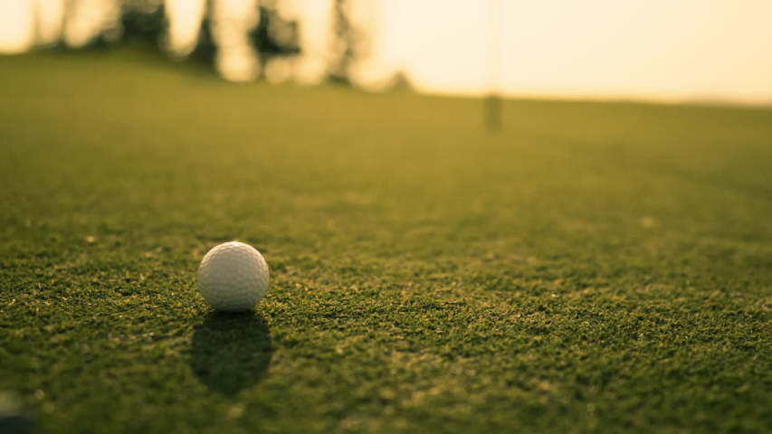 Putting Golf Ball on green in golf course hitting the golf ball to hole for birdie score, sports relax in holidays summer vacation at sunset golden time, cinematic Slow motion footage | Shutterstock HD Video #1041219301