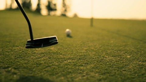 Putting Golf Ball on green in golf course hitting the golf ball to hole for birdie score, sports relax in holidays summer vacation at sunset golden time, cinematic Slow motion footage Stock Video