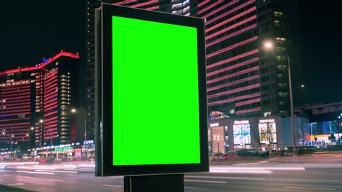 Modern billboard with a green screen on a busy highway with traffic, neon lights, timelapse of traffic at night, Moscow, Russia