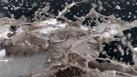 Drops of Milk and Chocolate Splashes Flying in Slow Motion on Black Background in Reverse Speed