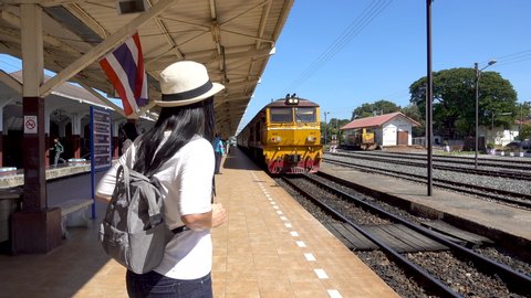 Phitsanulok Thailand - October 28, 2019: Asian tourist with a gray backpack is waiting for the train at the Phitsanulok train station