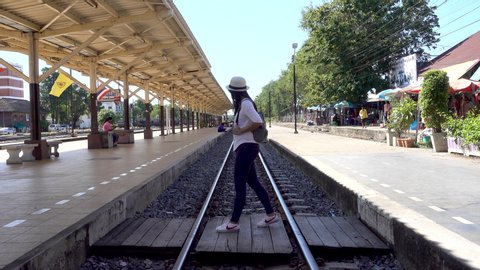 Phitsanulok Thailand - October 28, 2019: Asian tourist with a gray backpack is walking across the railway at Phitsanulok train station