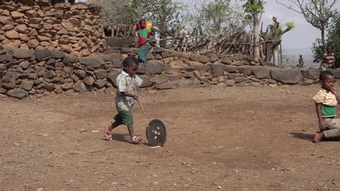 KONSO, ETHIOPIA – MARCH 2019: Happy young kids running on playground of small village in Ethiopia