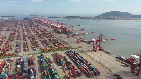 SHANGHAI, CHINA – SEPTEMBER 2019: Retreating aerial view of massive container terminal in the deep water Port of Shanghai, international trade global infrastructure in China