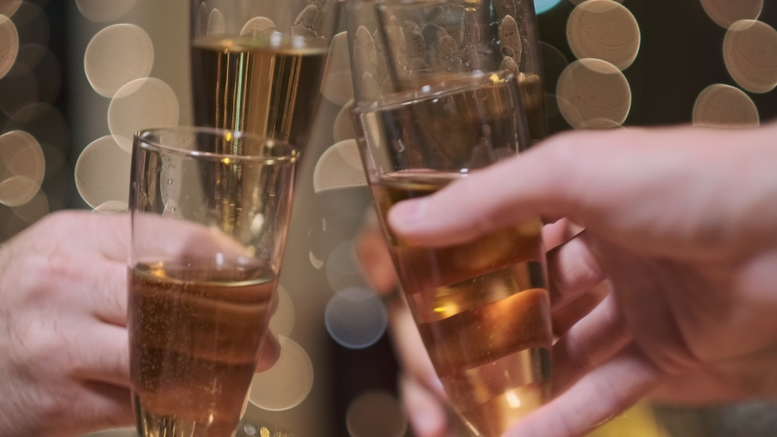Clinking glasses of champagne. Toast celebrating christmas. Yellow lights on the background. A lot of hands. A group of friends at a party. | Shutterstock HD Video #1041274213