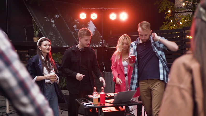 Party, DJ mixing music with mixing console while group of happy young people are dancing and drinking low alcohol drink having fun on celebration. Outdoors. Slow motion | Shutterstock HD Video #1041288073
