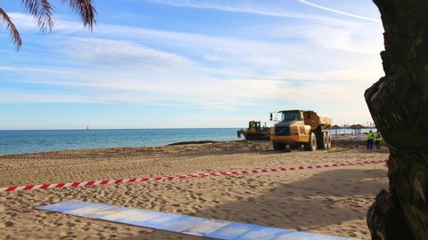 19 November 2019. Torremolinos, Spain. Construction work on beaches in La Carihuela area. Large dumper truck moving sand driving past slowly