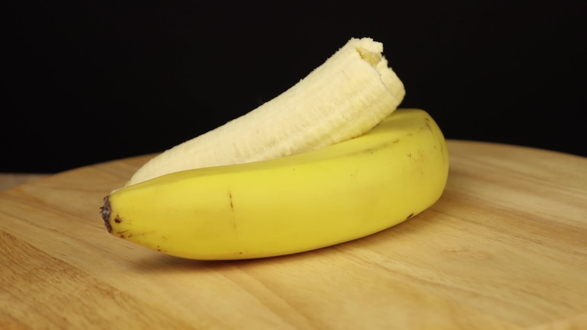 two bananas one whole and one without peel rotate 360 degrees