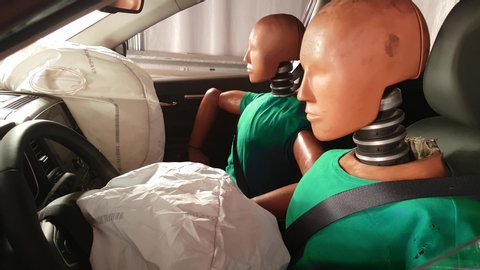 mannequins in a car after crash test. Smoke coming out of an airbag after an accident