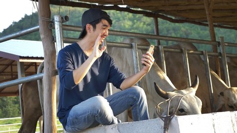 Young Asian Farmer video calling in farm, Waving and chat with family on smartphone camera
