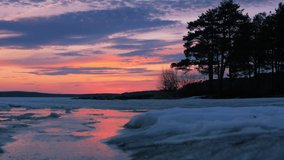 Beautiful pine trees silhouettes at frozen pond lake, epic colorful sunset sky in background. 4k UHD. - Powered by Shutterstock - Get 15% off with code: PIKWIZARD15