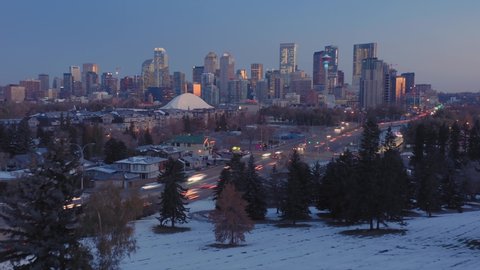 Aerial: Hyperlapse timelapse establishing shot of the Calgary city skyline at sunrise. The cars are moving fast in morning rush hour traffic 