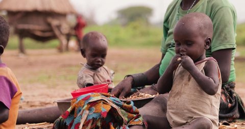 Karamoja / Uganda - 12 December 2019 Cute Child African Hungry Eating Food Outdoors on a sunny day in Karamoja Uganda.
