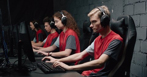 Young gamers puts on headphones, and start plays a video game, cyber sportsman at the game, communication between players, games tournament.